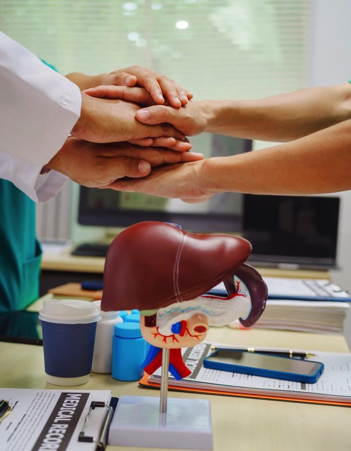 three-doctors-join-hands-at-a-hospital-table-after-2026-01-08-07-54-18-utc copy